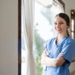 Portrait of a friendly female doctor or nurse wearing blue scrubs uniform and stethoscope, with